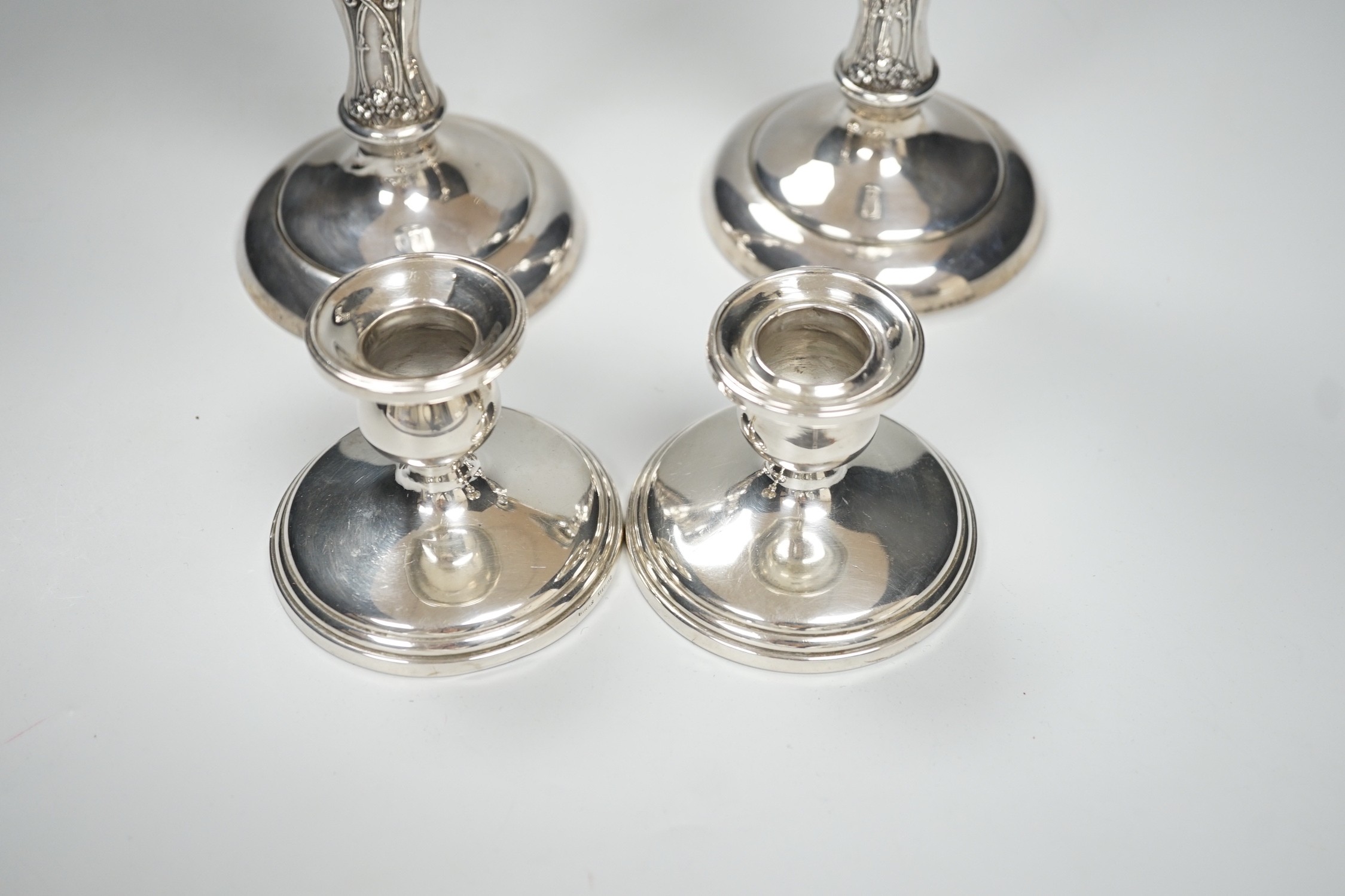 A pair of ornate sterling mounted candlesticks, 20.3cm, weighted and a pair of silver mounted dwarf candlesticks, 68mm, weighted.